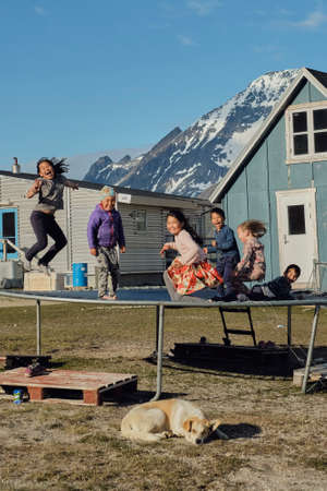 Greenlandic kids jumping on the trampoline in the village of Tasiusaqのeditorial素材