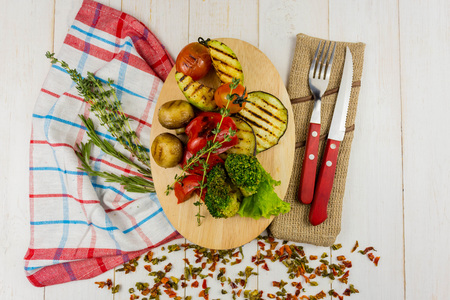 grilled vegetables on a wooden background with floats and greensの写真素材