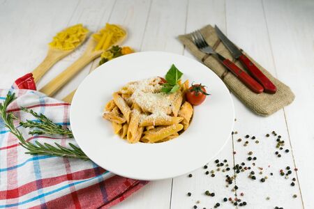 pasta with cheese on a wooden background with a linen towelの写真素材