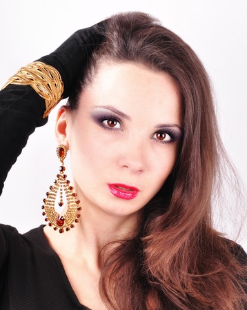 young beautiful dark-haired girl in extravagant earringsの写真素材