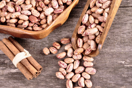 Colored beans in a wooden bowl on an old wooden backgroundの写真素材