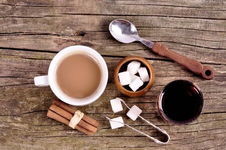 White mug with instant coffee and sugar bowl on an old wooden tableの写真素材
