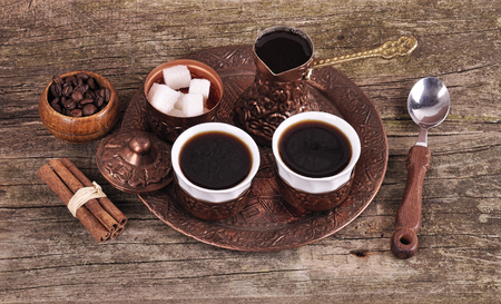 Coffee in copper coasters with accessories for coffee-drinking on old wooden backgroundの写真素材