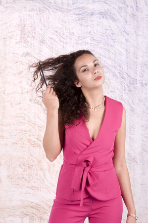 girl in a red suit combing her hairの写真素材