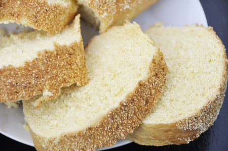 slices of sliced bread with cornmeal in a white plate on a dark background.