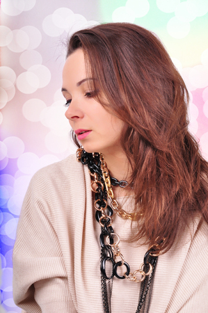 young beautiful brunette woman jewelry on abstract background.の写真素材