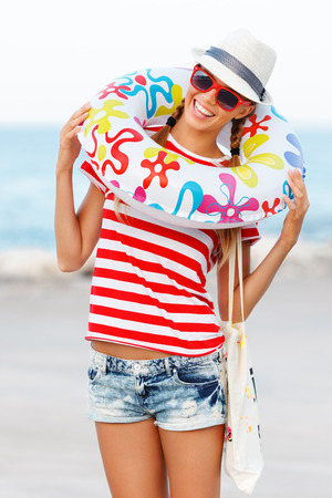 Beach woman happy and colorful wearing sunglasses and beach hat having summer fun during travel holidays vacation.の写真素材