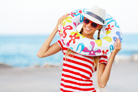 Beach woman happy and colorful wearing sunglasses and beach hat having summer fun during travel holidays vacation.の写真素材