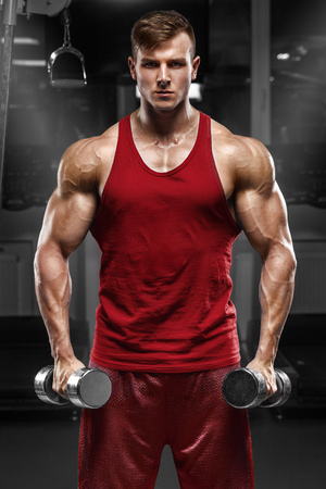 Muscular man working out in gym doing exercises, strong maleの写真素材