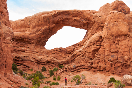 Travel in Arches National Park, man Hiker with backpack enjoying view South Window, outdoor lifestyle, Utah, USAの写真素材