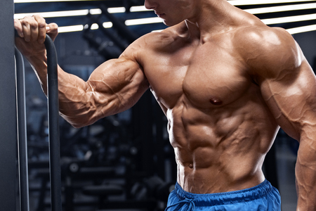 Muscular man working out in gym doing exercises for biceps. Strong male naked torso absの写真素材