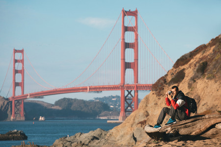 Travel in San Francisco, tourist man with camera in front of Golden Gate Bridge, San Francisco,...