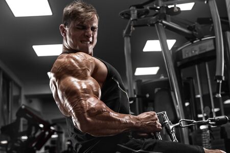 Muscular man workout in gym, doing exercise for back. Strong maleの写真素材