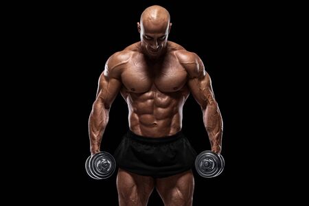 Muscular man isolated on the black background. Strong male naked torso abs
