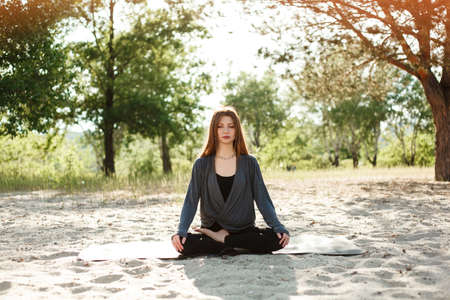 Woman doing yoga on the beachの写真素材