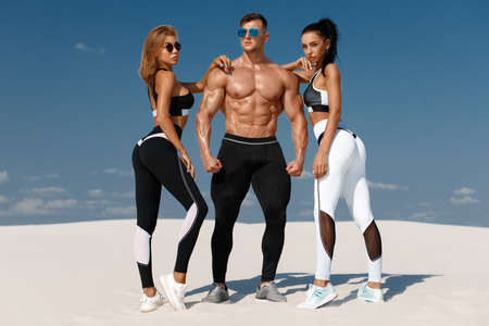 Sporty fitness models in sportswear. Athletic man and women in leggings outdoorの写真素材