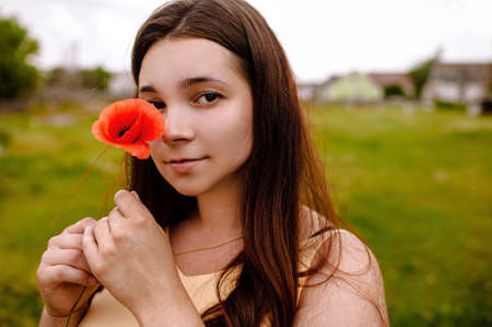 Young Attractive Woman With Red Poppy Seed