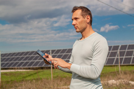 Engineer Using Laptop At Solar Panels Plant Field