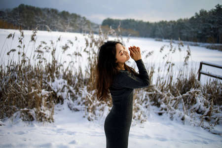 Portrait Of A Asian Woman Walks Near A Snowy Lake In Winter Parkの写真素材