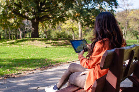 College Student Typing On Laptop While Sitting In Parkの写真素材