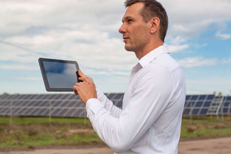 Engineer Using Laptop At Solar Panels Plant Fieldの写真素材