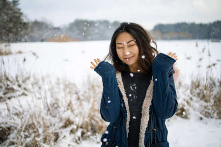 Portrait Of A Asian Woman Walks Near A Snowy Lake In Winter