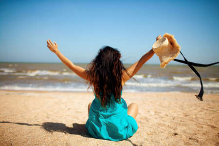 A beautiful asian young woman in dress dancing with smile on a sandy beach in Thailand.の写真素材