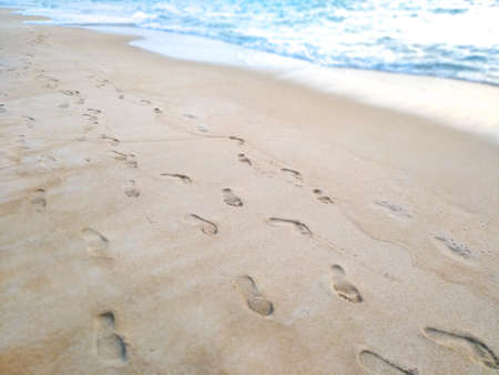 Footprints In The Sand At Sunset. Beautiful Sandy Tropical Beach With Sea Wavesの写真素材