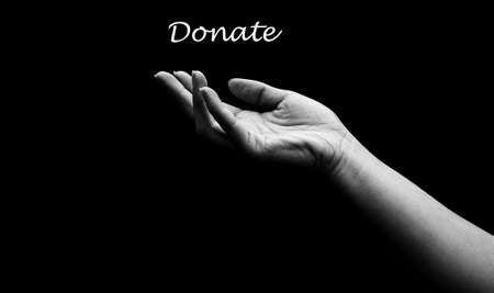 Donate Text Concept. Children's hand asks for helpの写真素材