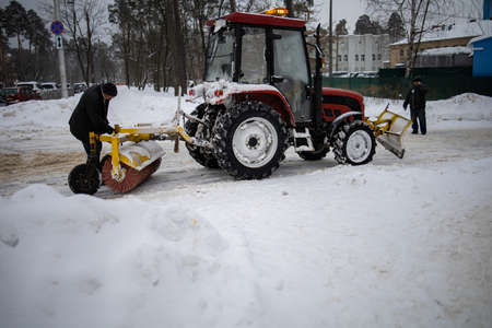 Tractor Cleans Snow With A Brush On The City Avenue.