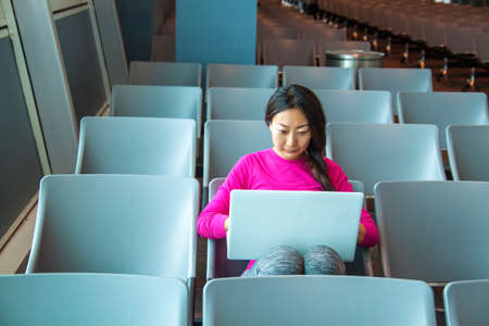 Beautiful woman working on a laptop at the airport.の写真素材