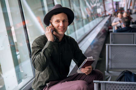 Happy business man waiting for his fligh in airport.