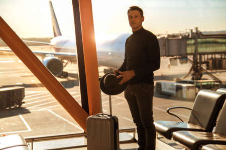 Happy business man waiting for his fligh in airport.