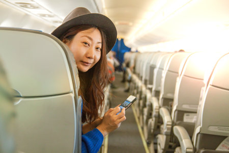 Elegant Mature Asian Woman Relaxing In Airplane. Woman Passenger Traveling In Airplane.の写真素材