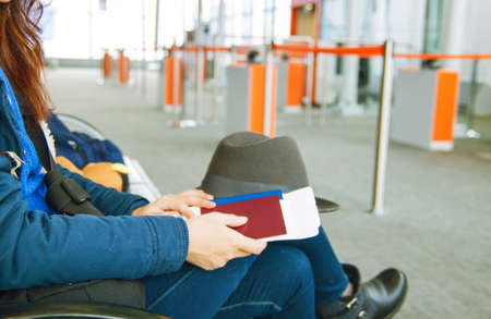Concept Of Tourism And Travel. Close-Up Female Hands Holding passport and ticket Sitting At Airport.の写真素材