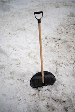 Big Black Plastic Shovel For Snow Cleaning Sticks Out In A Snowdriftの写真素材