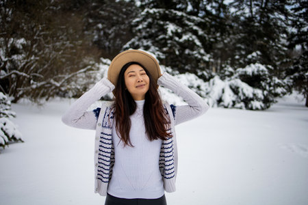 A Asian Woman Walking In The Snow In Woodland.の写真素材