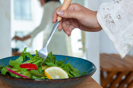 Young Woman Vegetarian Making Salad With Healthy Food In Modern Kitchen.