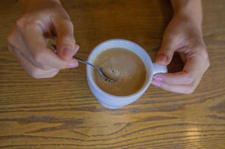 Woman's Hand Holding A White Cup Of Coffee