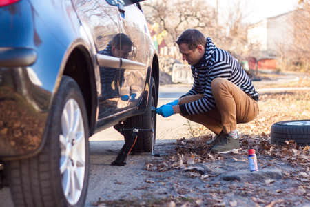 Auto Mechanic Changing Car Wheel With Electric Screwdriver