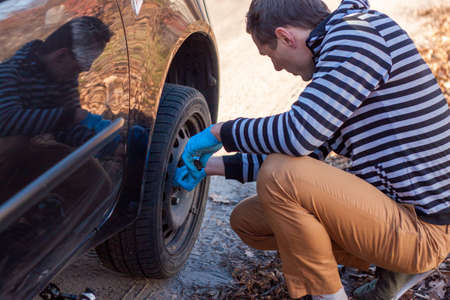 The driver changes the wheel of the car. Change summer wheels for winter.の写真素材