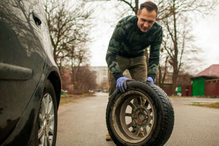 The driver changes the wheel of the car. Change summer wheels for winter.の写真素材