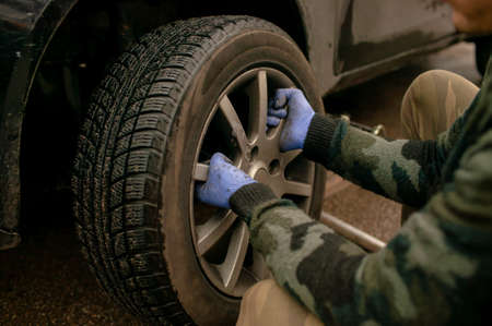The driver changes the wheel of the car. Change summer wheels for winter.の写真素材