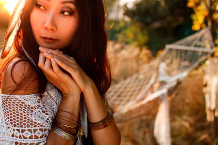 Young Beautiful And Mysterious Asian Woman Holding Dreamcatcher In field.