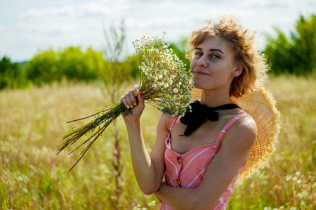 Caucasian Woman In Dress with curly hair Enjoing Wildflowers In Summer Fieldの写真素材