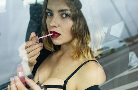 Close Up Of Beautiful Woman Getting Her Lips Painted While Sitting In Car.