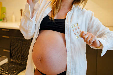 Smiling Pregnant Woman Is Sitting In Bedの写真素材