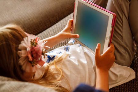 Girl using digital tablet on sofa at home.の写真素材