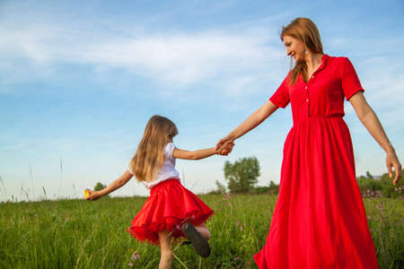 happy family mother and daughter hugging in summer on the nature.の写真素材
