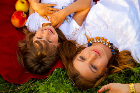 happy family mother and daughter hugging in summer on the nature.の写真素材